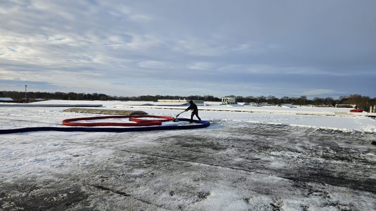 Sneeuw verwijderen van dak in Ter Apel