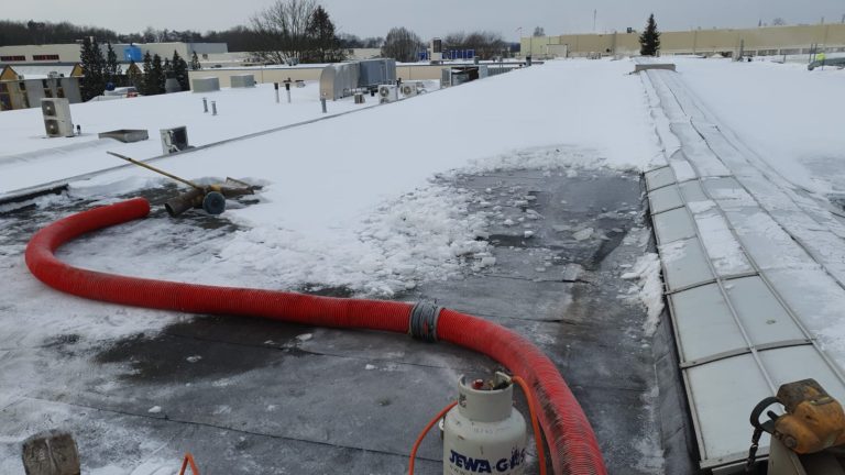 Sneeuw van dak zuigen